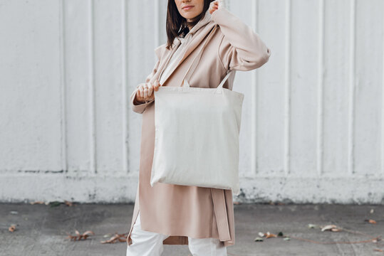 Woman In Coat With White Cotton Bag On Her Shoulder. Mockup And Zero Waste Concept.