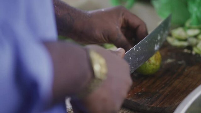african man cutting limes with a knife