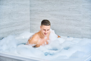cheerful guy in bubble bath