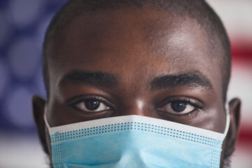 Close-up of African young man wearing protective mask during pandemic he looking at camera