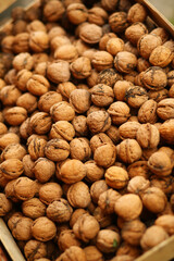 Closeup of autumn harvest of ripe walnuts gathered in a box outdoors, aerial view