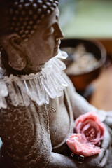 Close up detail still life of Buddha statue with crystal quartz necklace