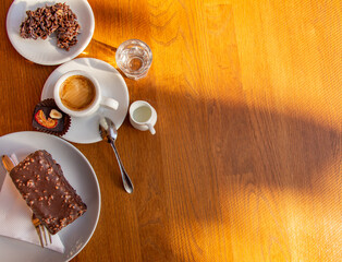 cup of espresso with cream and chocolate candy, cake, cookies on a wooden table. Cafe concept.