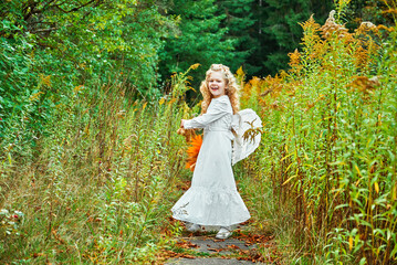 portrait of a little girl in a white dress. angel with wings