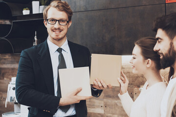 Smiling manager in suit is showing materials.