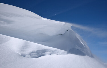 Schneetreiben auf  einer Schneewächte bei blauem Wetter