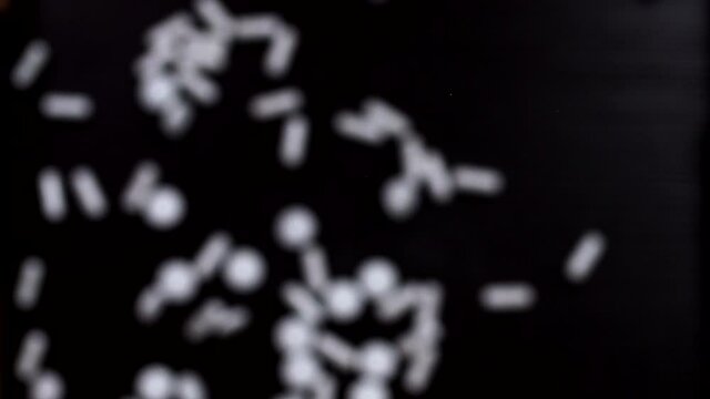 Pharmaceutical drugs on a black background. Super slow motion. Macro