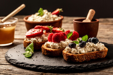 Traditional American and European summer breakfast: sandwiches of toast with cheese ricotta blueberries, strawberries, raspberries