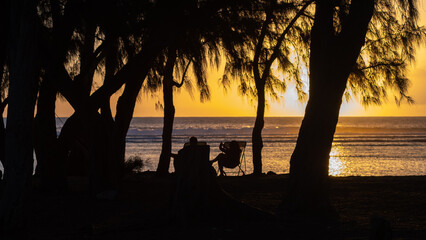 People on the beach watching the sunset on the Indian Ocean