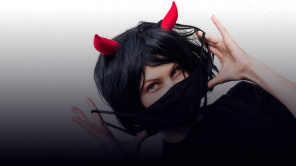 woman wearing a black medical mask and a wig with red horns