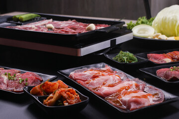 Raw beef slice for barbecue japanese style, yakiniku. Meats are being cooked on stove.