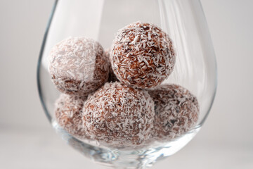 Date sweets with coconut shavings in a wine glass close-up