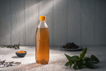 Cold green tea with mint oil near mint leaves in a misted plastic bottle