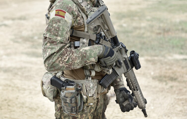 Soldier with assault rifle and flag of Spain on military uniform. Collage.