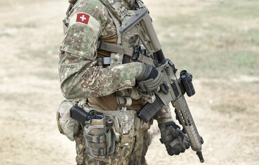 Soldier with assault rifle and flag of Switzerland on military uniform. Collage.