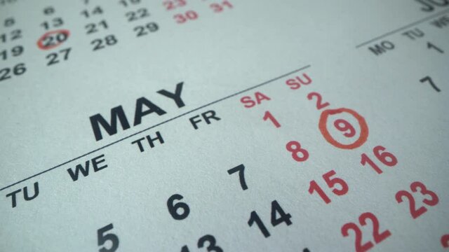 May 9 is day of liberation from fascism, end of the second world war. Calendar 2021 year. Man circle important date with red pen. Macro shot. Holidays of next year