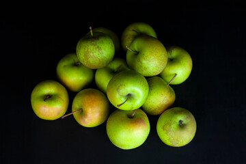 Fresh harvest of green apples on a black background, farm organic fruits