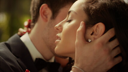 Fancy bride and groom posing before wedding in park. Couple hugging outdoors
