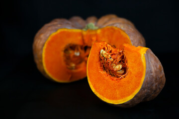 Orange pumpkin cutaway on a black background, farm organic vegetables