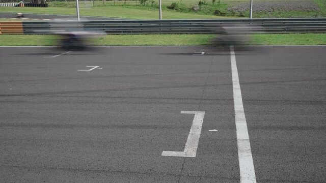 Motorcycle riders speeding and passing racing line