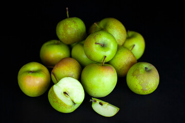 Fresh harvest of green apples on a black background, farm organic fruits
