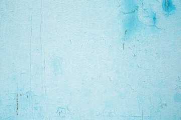 The texture of the old wall with cracked peeling blue paint. Background.