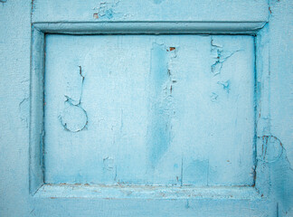 The texture of the old wall with cracked peeling blue paint. Background.