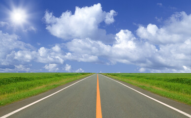 草原の直線道路と雲と太陽