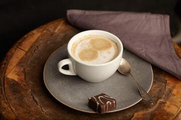 a cup of coffee with candy on the table in the home.