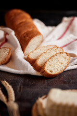 Assorted different types of bread, gluten-free bread, close-up on a dark background. French baguette with sesame seeds. Place for text