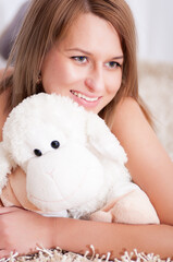 beautiful woman wearing pajamas hugging her lamb