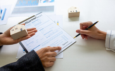 Close up of Hands Business woman signature on contract to buy or sell real estate.