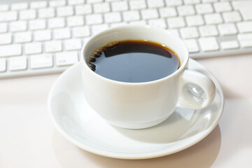 パソコンのキーボードとホットコーヒー