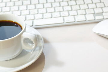 パソコンのキーボードとホットコーヒー