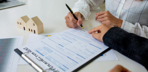 Close up of Hands Business woman signature on contract to buy or sell real estate.