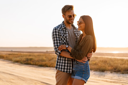 Beautiful happy couple hugging and smiling while strolling on nature