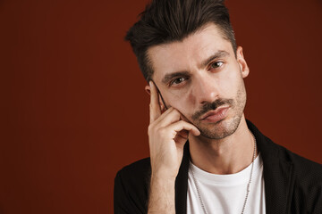 Photo of confident man looking at camera and touching his temple