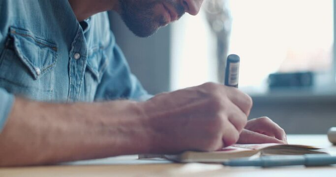 Close Up of Handsome Hipster Artist is drawing something on the Paper. Young Caucasian Male is drawing focused, meditating. Creative People, Person. Art as a Hobby, Profession.