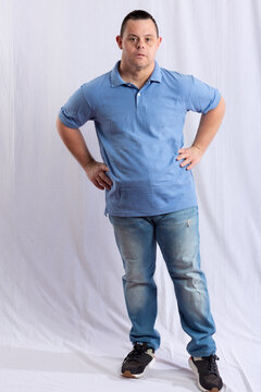 a happy man with Down syndrome in a white background photo studio wearing jeans