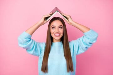 Fototapeta na wymiar Photo of attractive funny lady hold book hands above head spend free time hobby tricky behavior mood wear knitted blue pullover isolated pastel pink color background