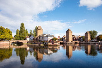 Fototapeta na wymiar Scenic view on Ponts Couverts in Strasbourg. View on the towers reflecting in water, picturesque landscape of Strasbourg La Petite France district, Ill river canal, Alsace, France.