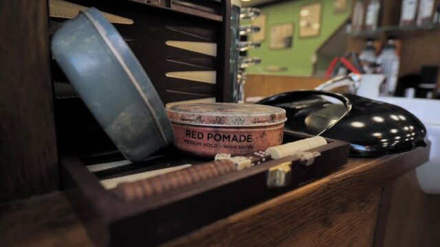 a cinematic shot of a pomade can onto the table in the barber shop