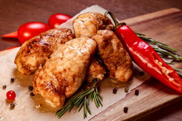 White meat fried chicken on charcoal with sauce and fries on a wooden board.