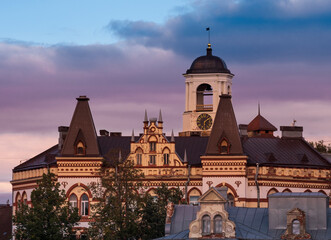 Old white clock tower in old Vyborg city, Russia at sunset in autumn