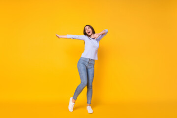 Fototapeta na wymiar Full length body size view of her she attractive pretty slender careless cheerful cheery girl having fun dancing spending weekend isolated bright vivid shine vibrant yellow color background
