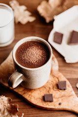 Close-up of hot chocolate in a ceramic mug on the table. Autumn or winter cozy still life.