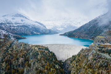 Hydropower generated from arch dam and reservoir lake in snow covered Swiss Alps mountains to...