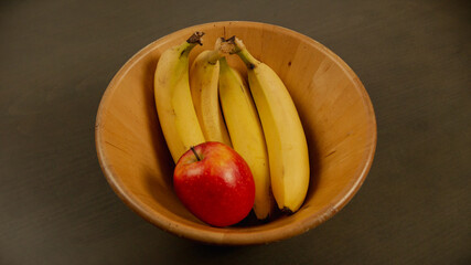 plátanos y manzana en el frutero