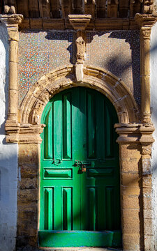 Rustic green wooden front door with padlock.