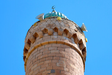 The top, the roof of the minaret with the symbol of the crescent moon and the speakers through...